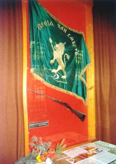 The flag of Volov’s detachment (a reconstruction) bearing the motto “Freedom or Death”, with his rifle below it
