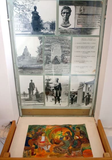 A display case of documents with a child’s drawing beneath it